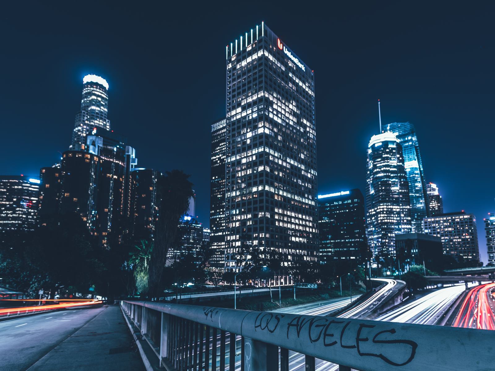 Light trails of traffic below a downtown skyline at night