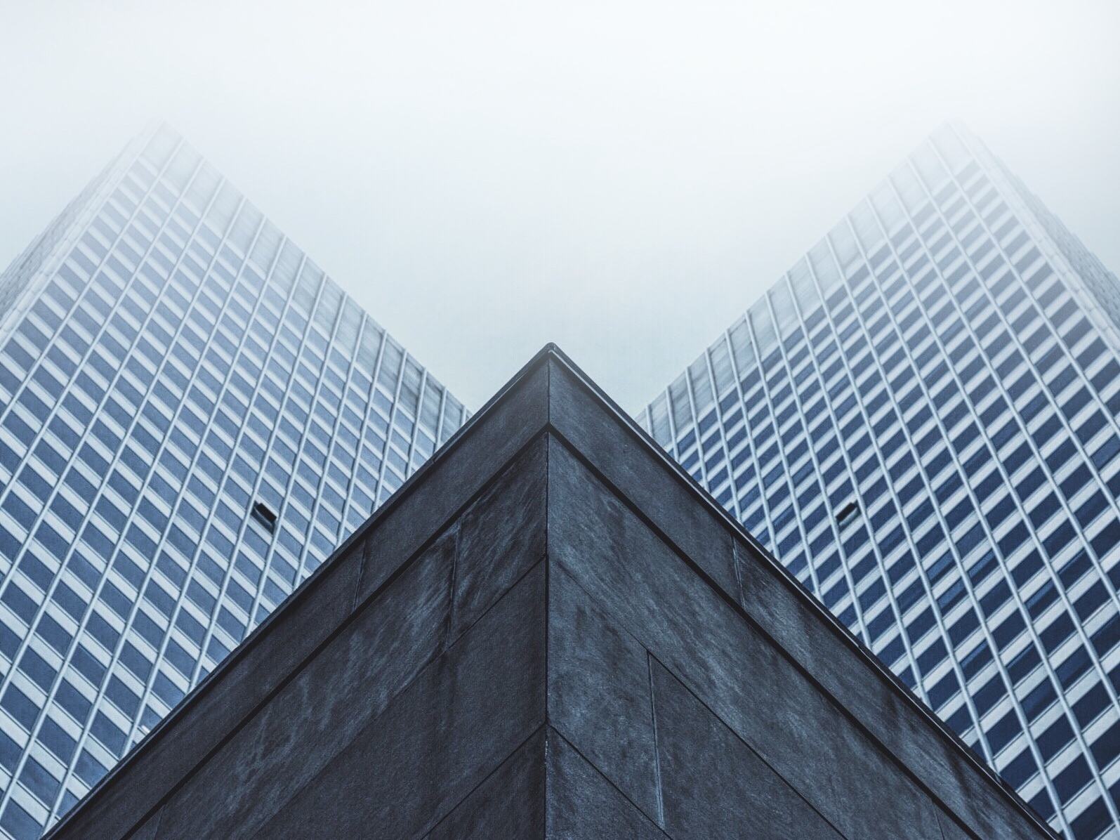 Two office towers rising into low cloud