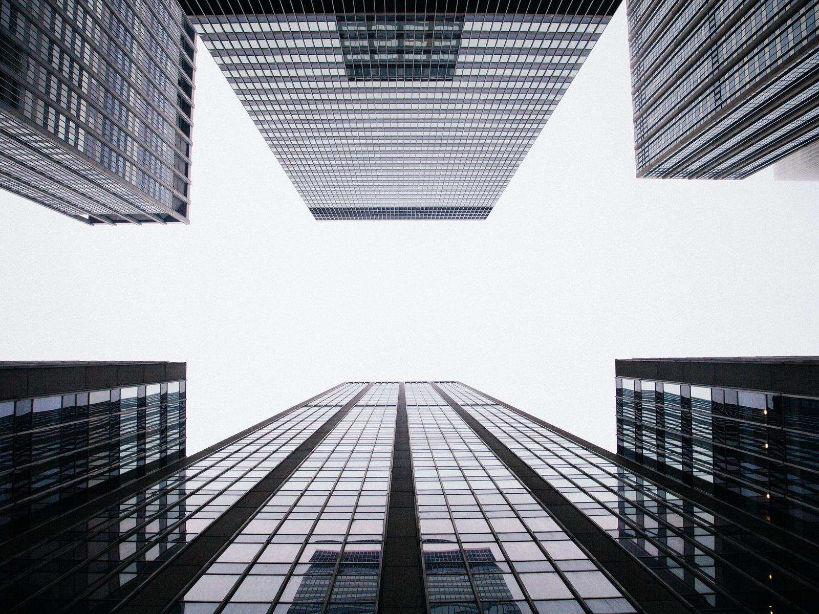 Looking up between glass office towers