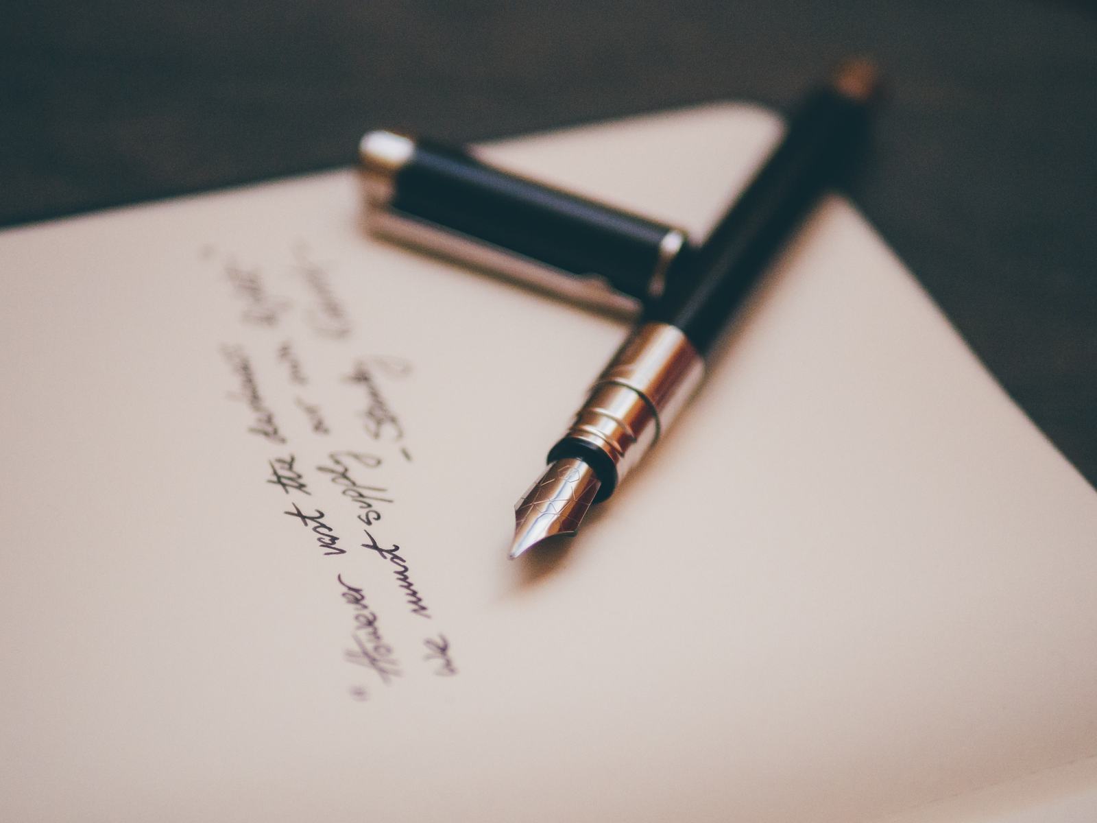 A fountain pen resting on a handwritten page